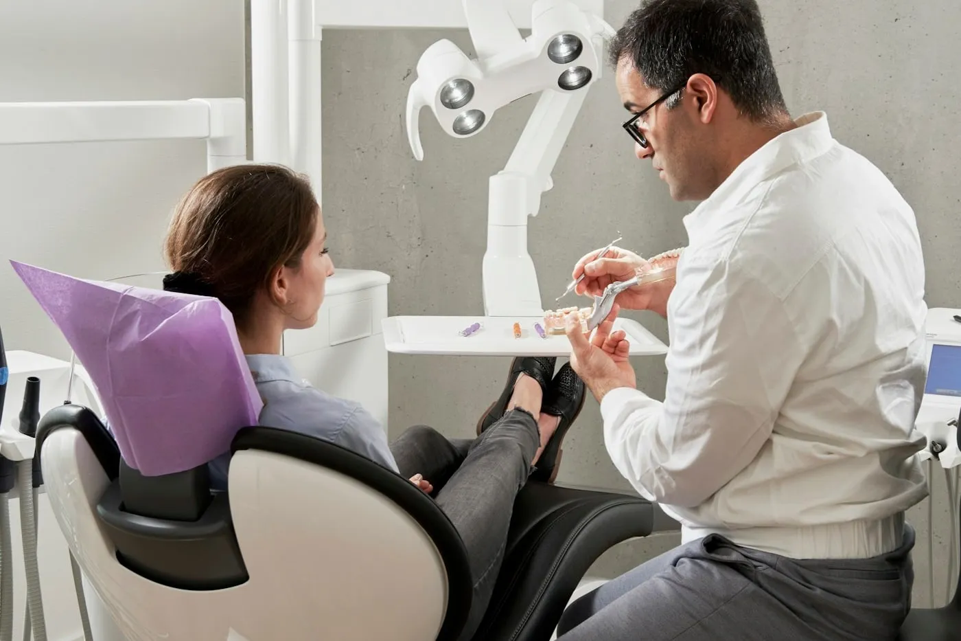 Dentista atendiendo a una paciente en su consultorio